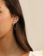 Heart of Freedom Stud Earring styled with a heart-shaped moissanite chain earring in solid gold.