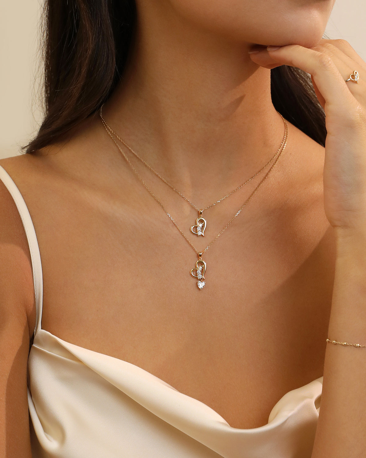Model wearing two Meissa Heart of Freedom Necklaces in solid gold in an elegant layered necklace look.
