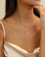 Model wearing two Meissa Heart of Freedom Necklaces in solid gold in an elegant layered necklace look.