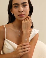 Model styling layered Meissa Heart of Freedom Necklaces in solid gold with matching heart jewelry.
