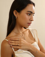 Close-up of model wearing layered Meissa Heart of Freedom Necklaces in solid gold with coordinating heart rings and bracelet.