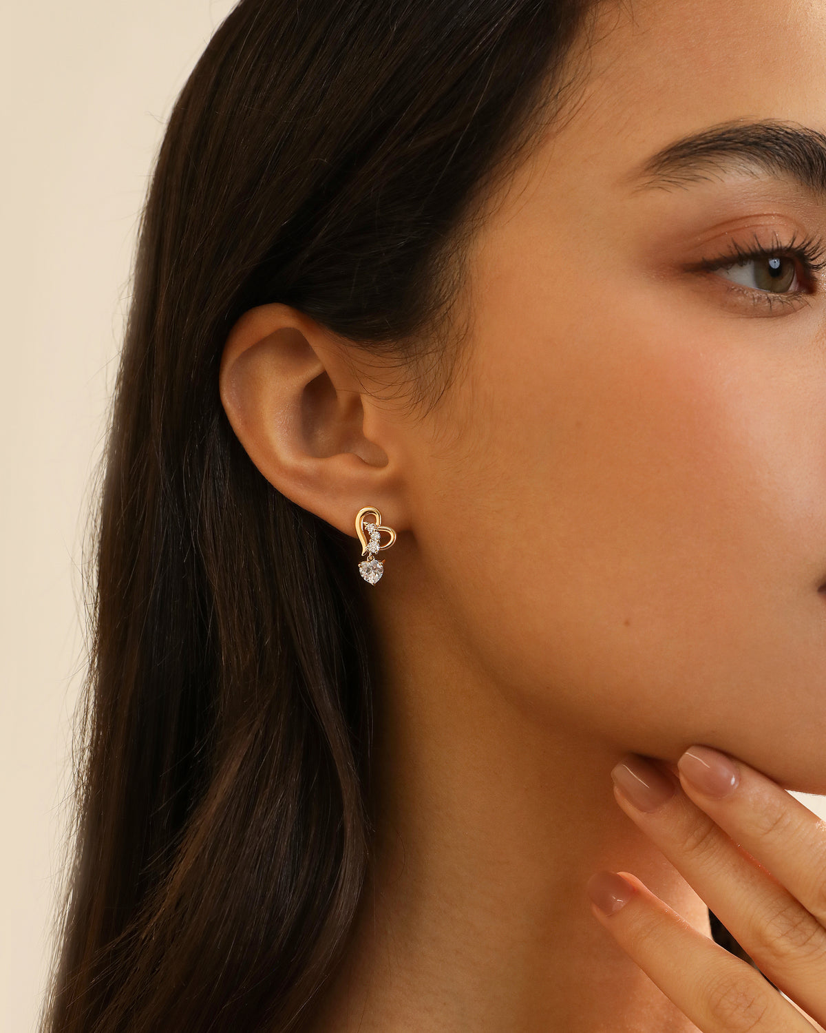 Heart of Freedom Stud Earring in solid gold worn on the ear with three sparkling moissanite stones.