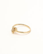 Side view of Waves of Love Ring in solid gold showing the heart setting and moissanite details.