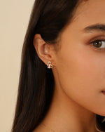 Heart of Freedom Stud Earring in solid gold worn on the ear with sparkling moissanite accents.