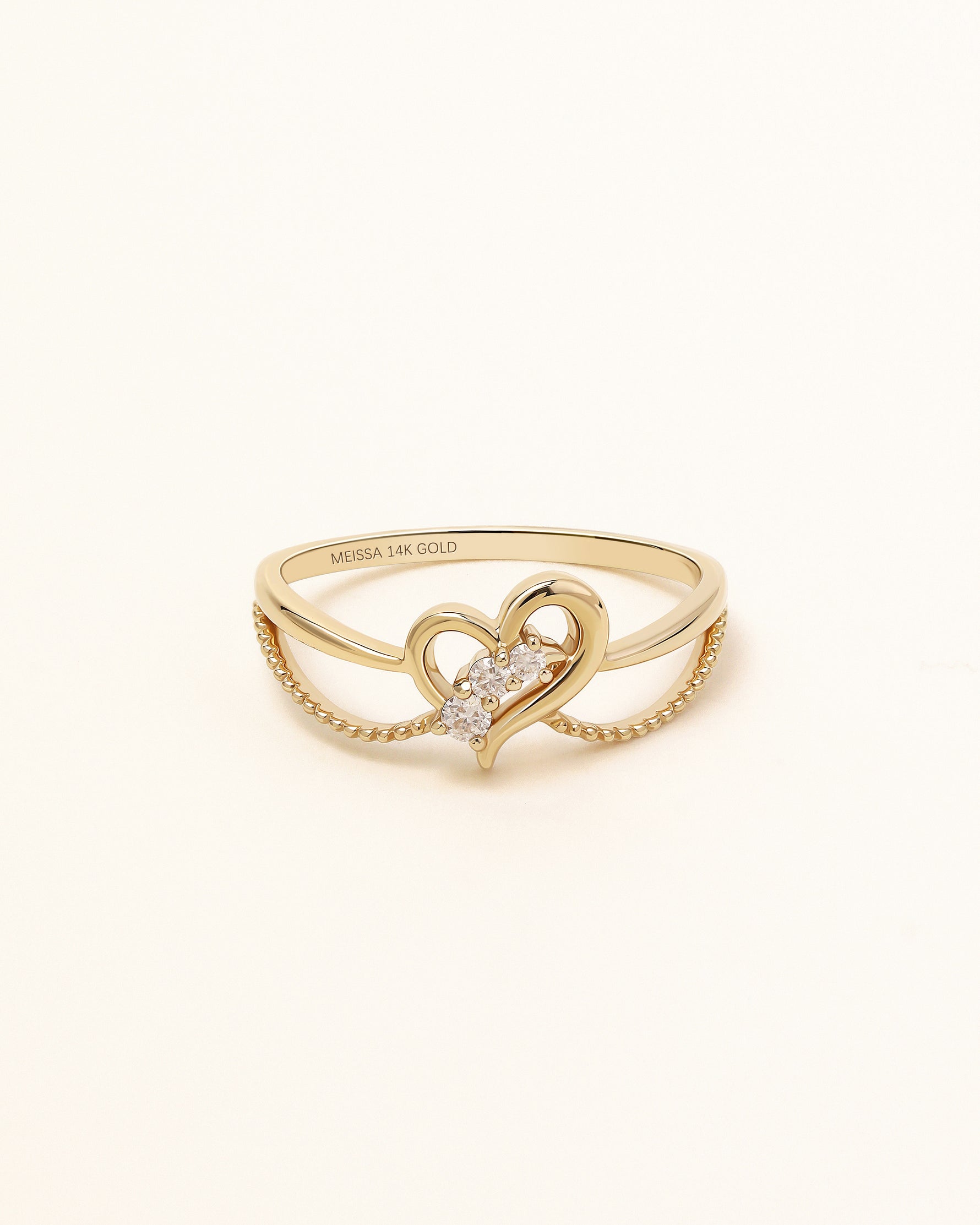 Front view of Wings of the Heart Ring in solid gold with open heart centerpiece and sparkling moissanite stones.