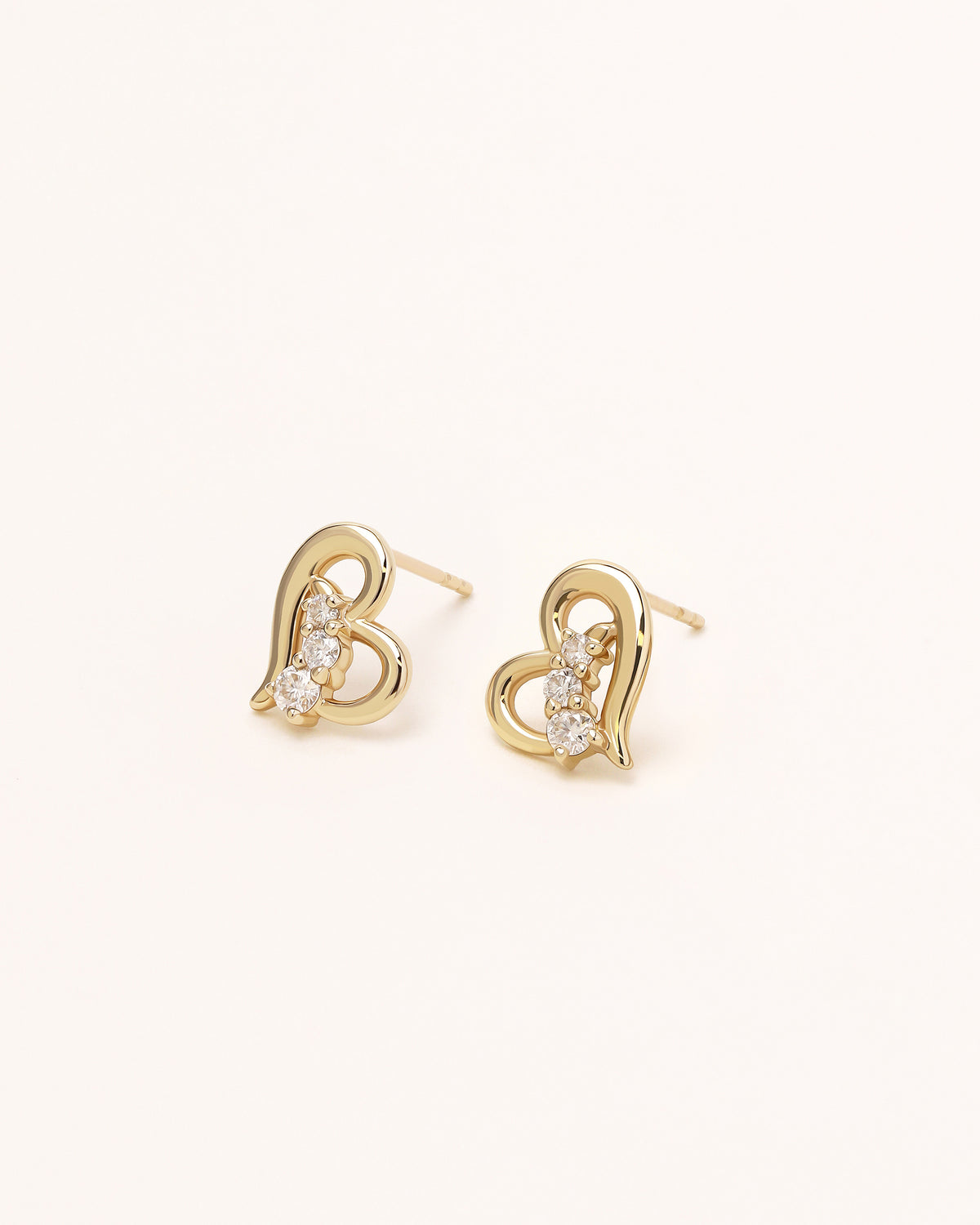 Pair of Heart of Freedom Stud Earrings in solid gold with open heart design and moissanite stones.