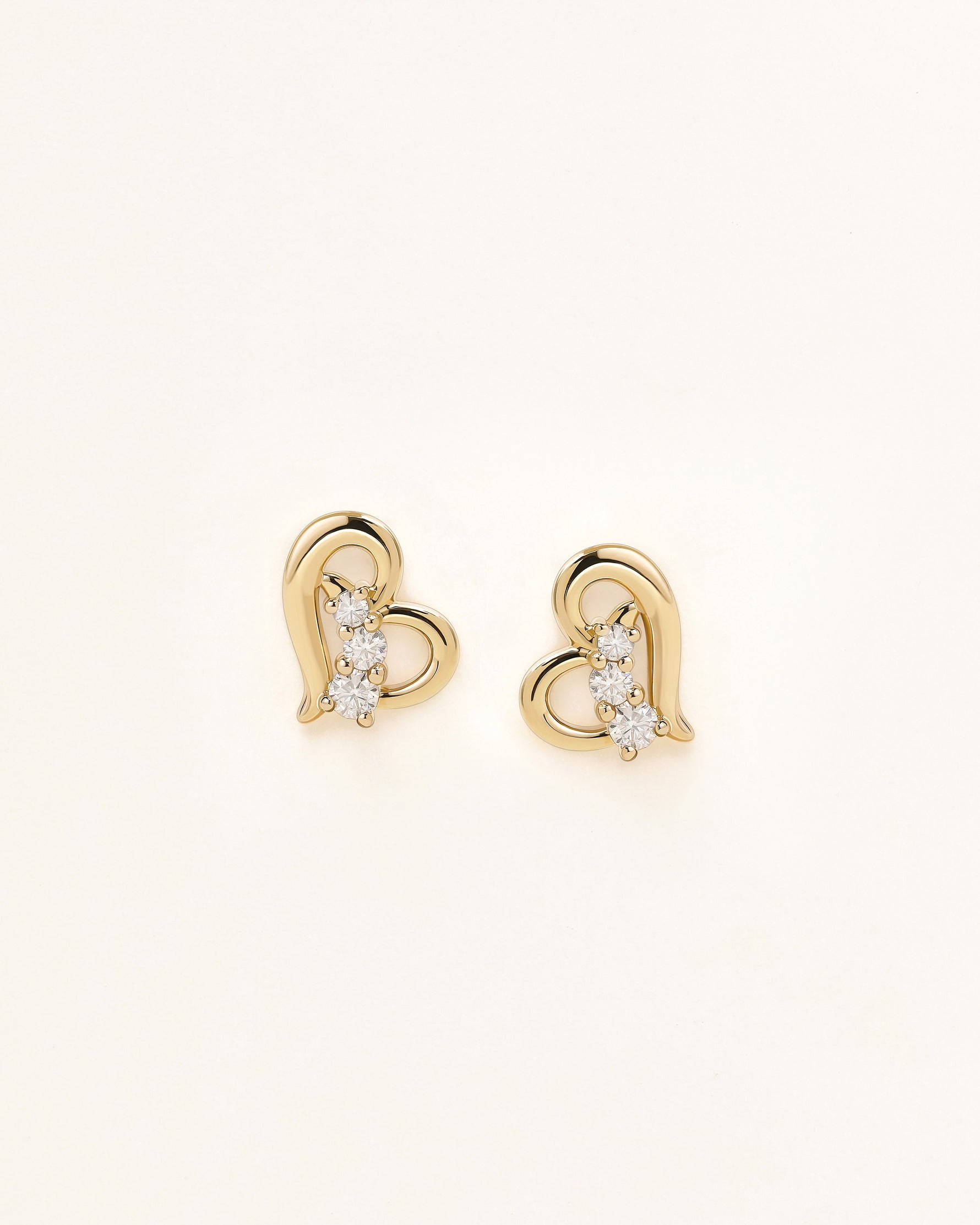 Front view of Heart of Freedom Stud Earrings in solid gold with heart motif and three moissanite stones.