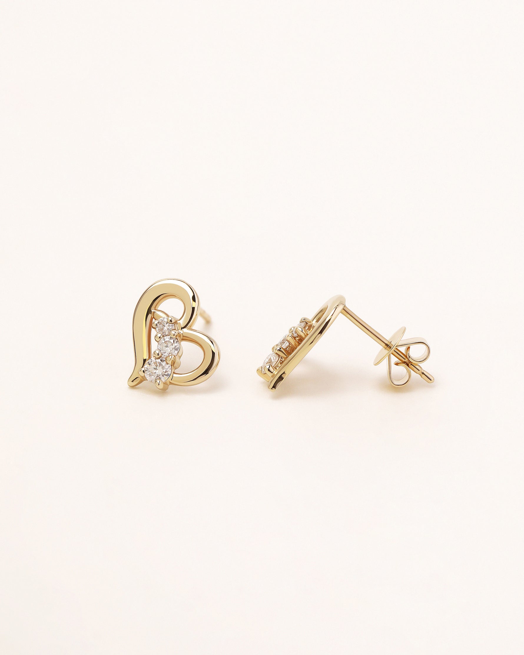 Heart of Freedom Stud Earrings in solid gold shown from the front and side with butterfly backs.