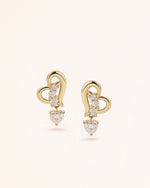 Front view of Heart of Freedom Dangle Earrings in solid gold with open heart motif and moissanite accents.