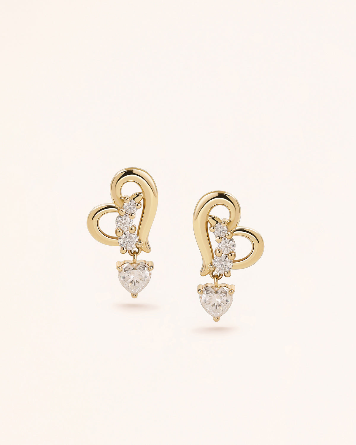 Front view of Heart of Freedom Dangle Earrings in solid gold with open heart motif and moissanite accents.
