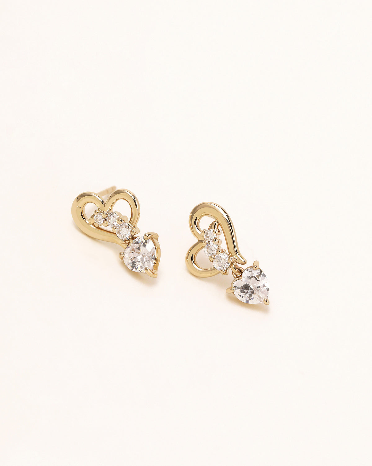 Pair of Heart of Freedom Dangle Earrings in solid gold with sparkling  and dangling heart-shaped moissanite.