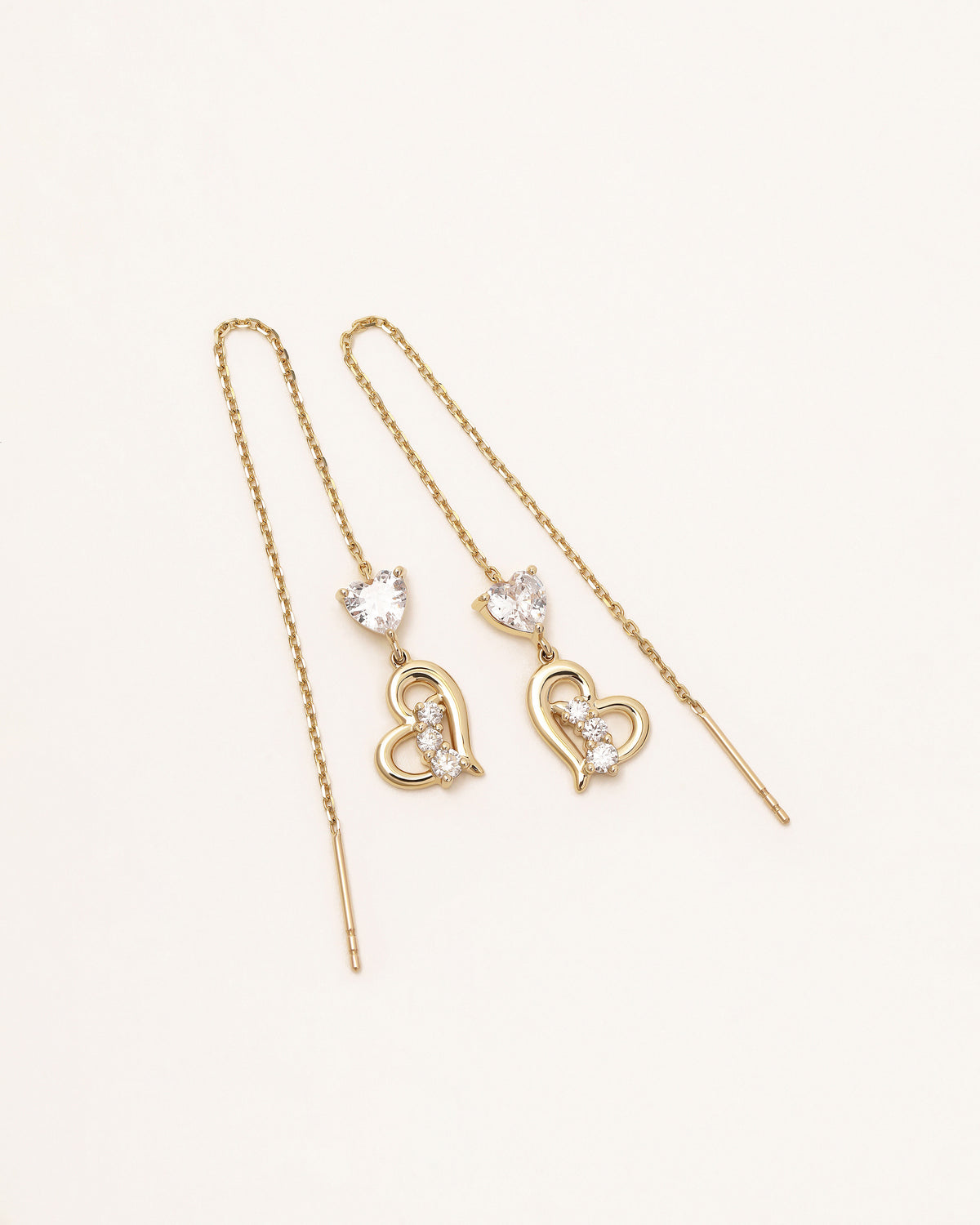 Pair of Heart of Freedom Threader Earrings in solid gold with delicate chain drops and sparkling heart details.
