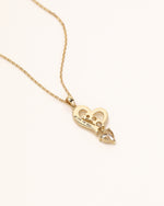 Back view of Dancing Heart Necklace in solid gold showing Meissa 14K gold engraving and moissanite setting.