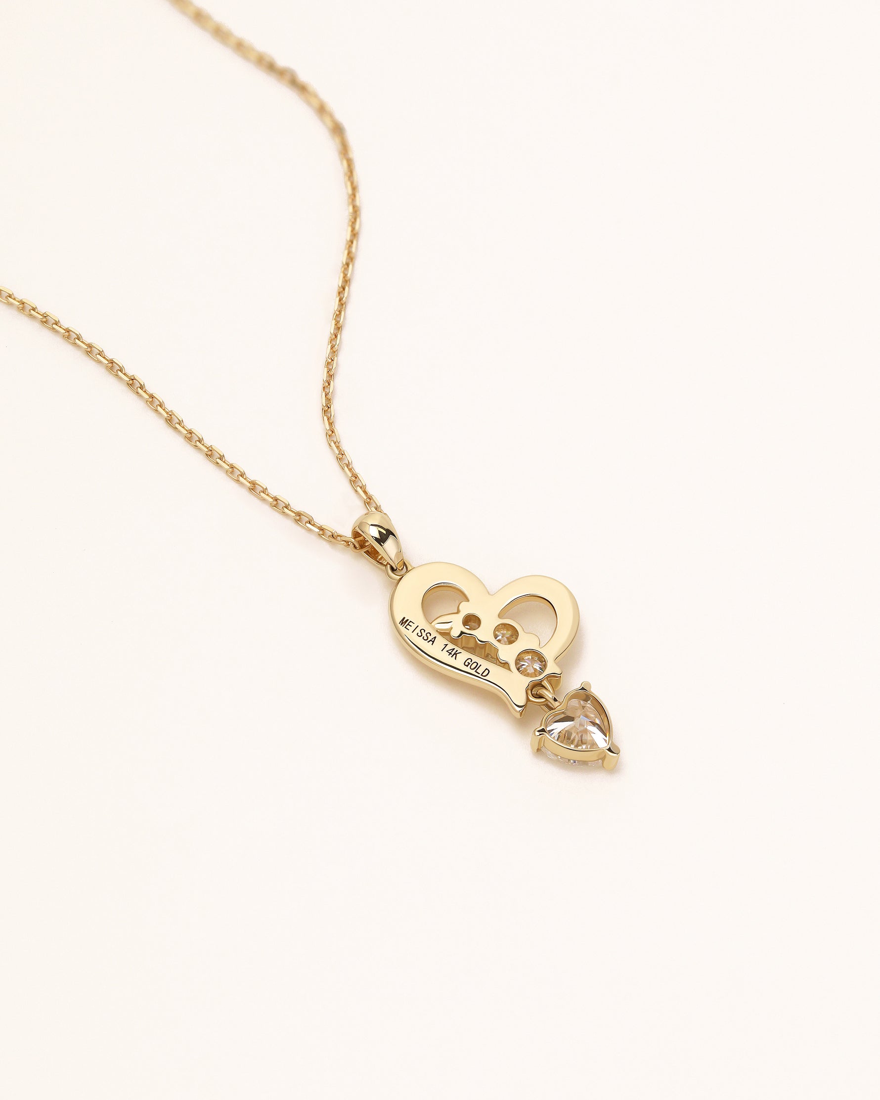 Back view of Dancing Heart Necklace in solid gold showing Meissa 14K gold engraving and moissanite setting.