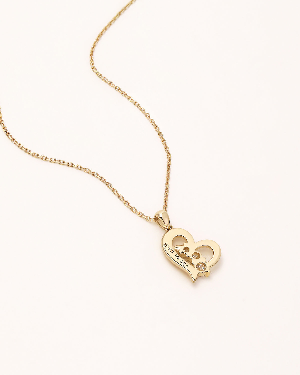 Back view of Meissa Heart of Freedom Necklace showing the polished solid gold heart pendant.