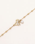 Close-up of Heart of Freedom Bracelet in solid gold with heart motif and heart-shaped moissanite drop.