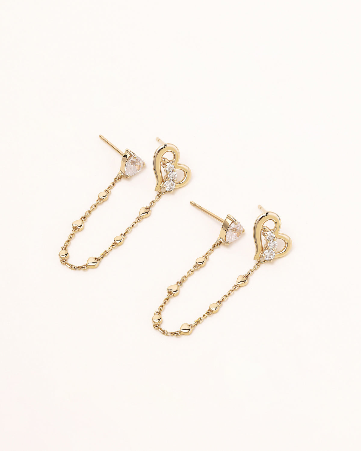 Pair of Heart of Freedom Chain Earrings in solid gold with heart-shaped moissanite and open heart charms connected by fine chains.
