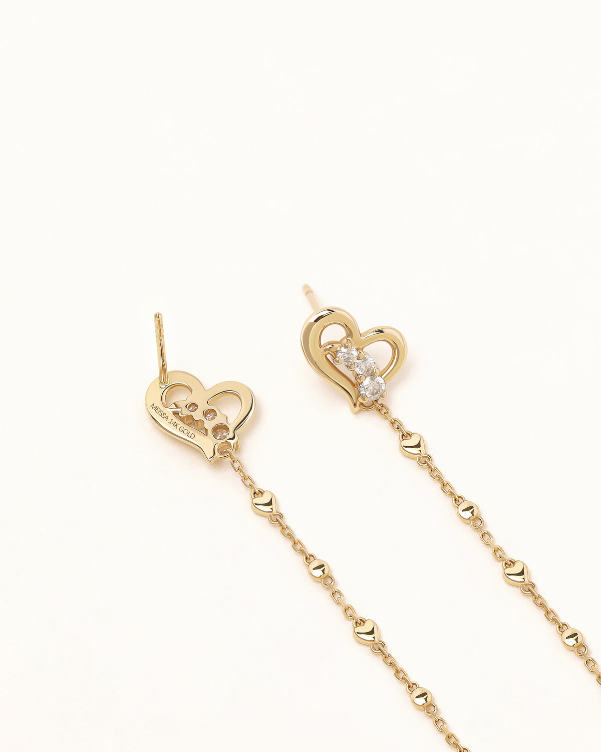 Front and back view of Heart of Freedom Chain Earrings in solid gold with open heart charms, sparkling moissanite, and delicate chain drops.