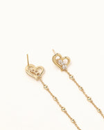 Front and back view of Heart of Freedom Chain Earrings in solid gold with open heart charms, sparkling moissanite, and delicate chain drops.