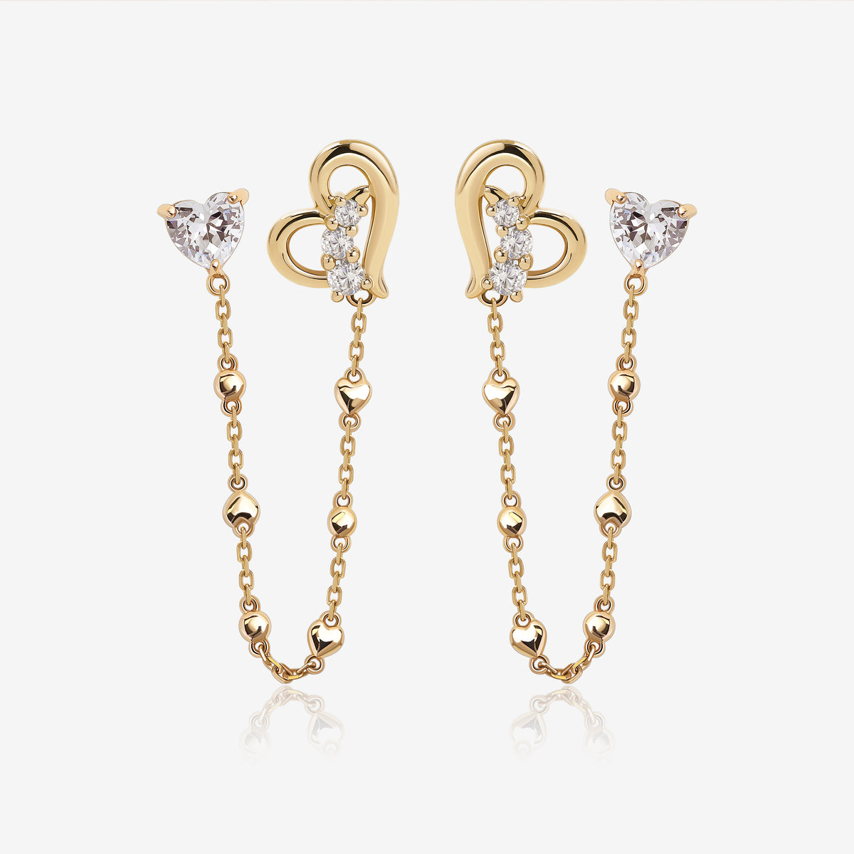 Heart of Freedom Chain Earrings in solid gold with heart-shaped moissanite studs, open heart charms, and delicate chain details.