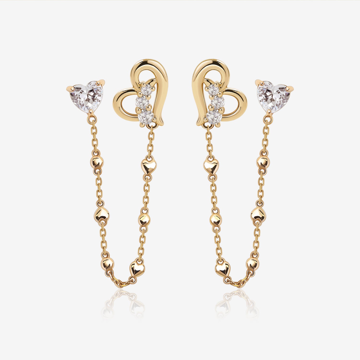 Heart of Freedom Chain Earrings in solid gold with heart-shaped moissanite studs, open heart charms, and delicate chain details.