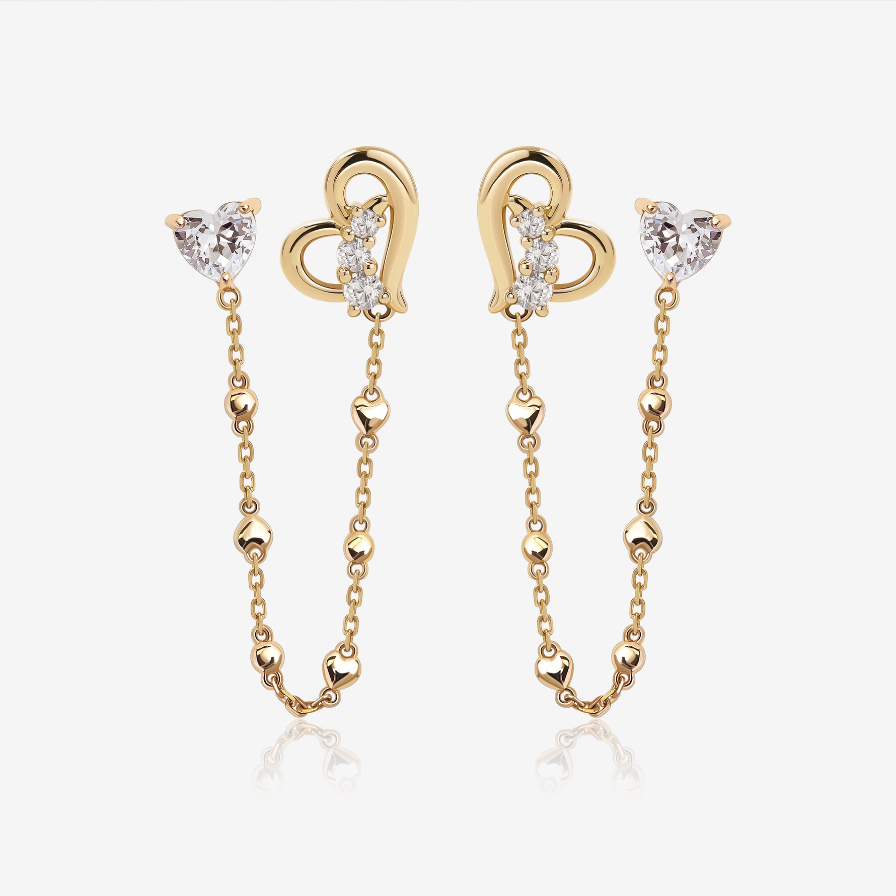 Heart of Freedom Chain Earrings in solid gold with heart-shaped moissanite studs, open heart charms, and delicate chain details.