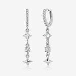 Starlight Drop Huggie Earrings shown as a pair, featuring pavé huggie hoops with dangling square and round sparkling stones and a small star charm.