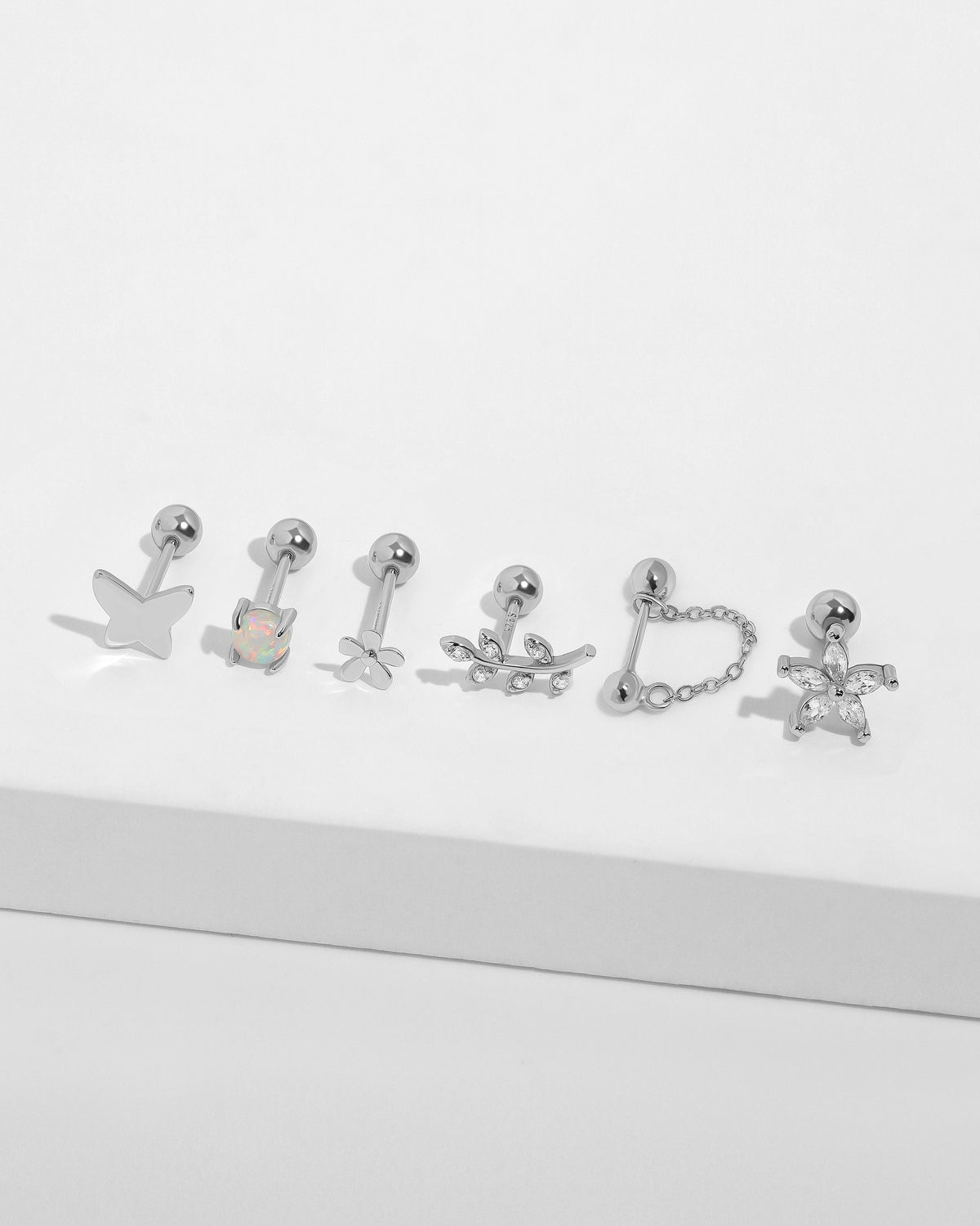 Spring Meadow Earrings Set in 925 sterling silver displayed with butterfly, opal, flower, leaf and cubic zirconia designs.