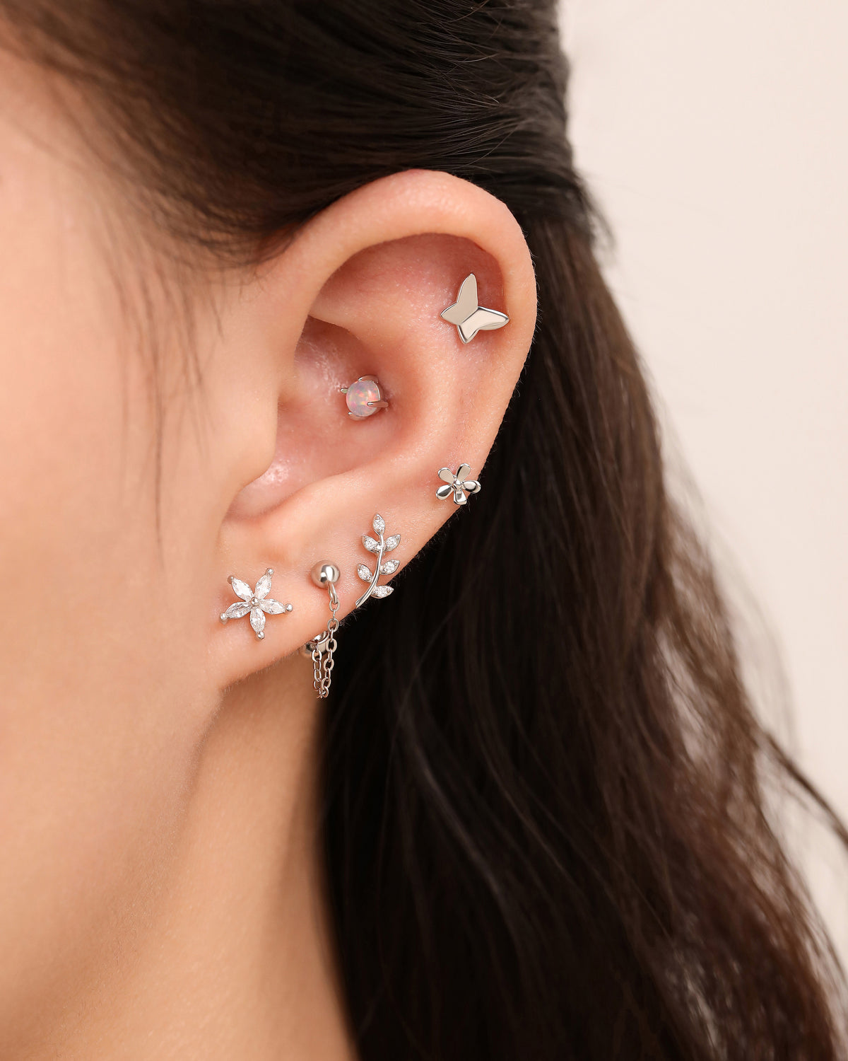 Model wearing Spring Meadow Earrings Set in 925 sterling silver with butterfly, opal, flower, leaf and chain earrings.
