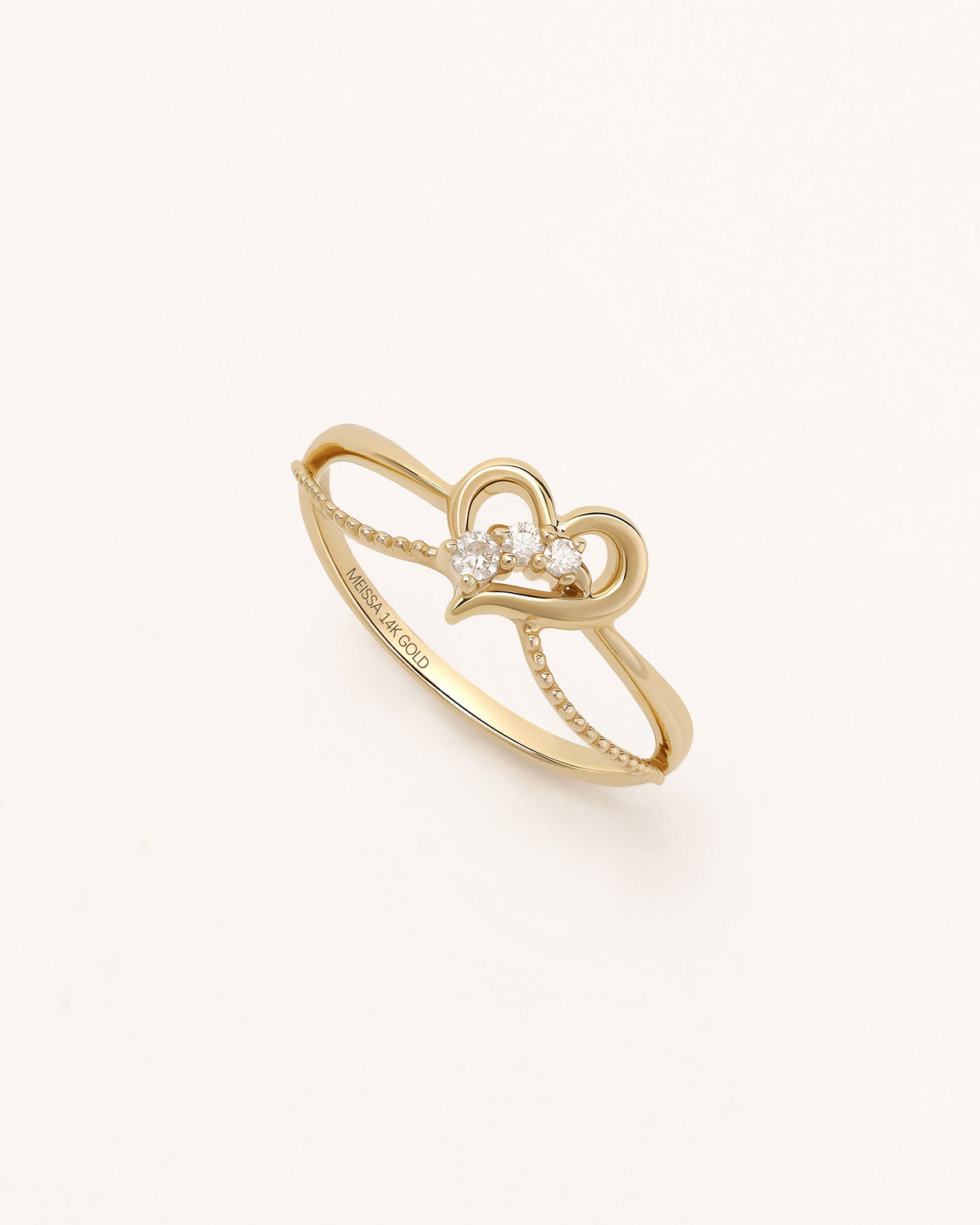 Angled view of Wings of the Heart Ring in solid gold with layered heart motif and moissanite accents.