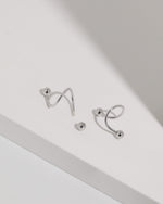 Ball Spiral Screw Back Earrings in silver color shown with one screw back ball removed to display the threaded post and fastening design.