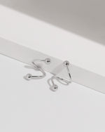 Ball Spiral Screw Back Earrings arranged on a white display with polished ball ends and a smooth curved design.