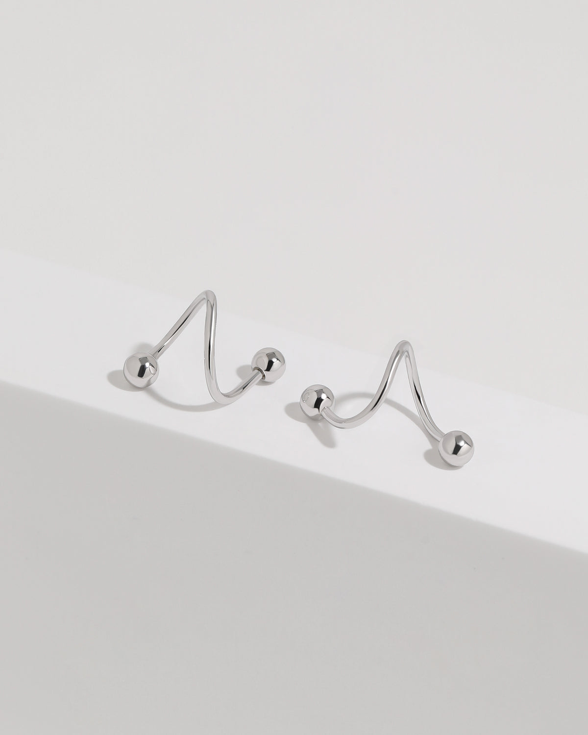 Ball Spiral Screw Back Earrings in silver color displayed from multiple angles on a white surface, highlighting the sculptural spiral construction.