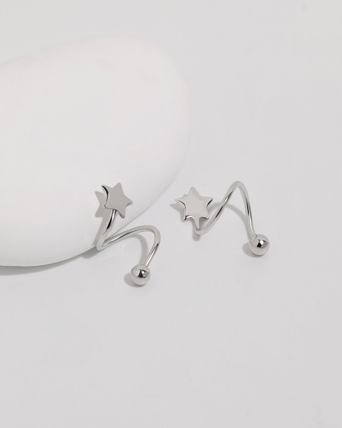 Star Spiral Screw Back Earrings displayed from an angled view with polished star details and round screw backs.