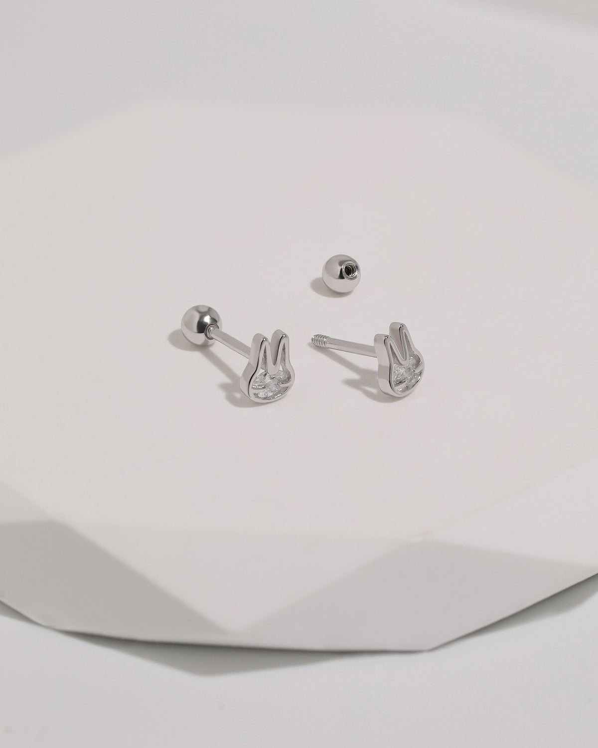 Pair of silver Meissa Bunny Sparkle Screw Back Earrings shown with threaded posts and removable round screw backs on a white surface.