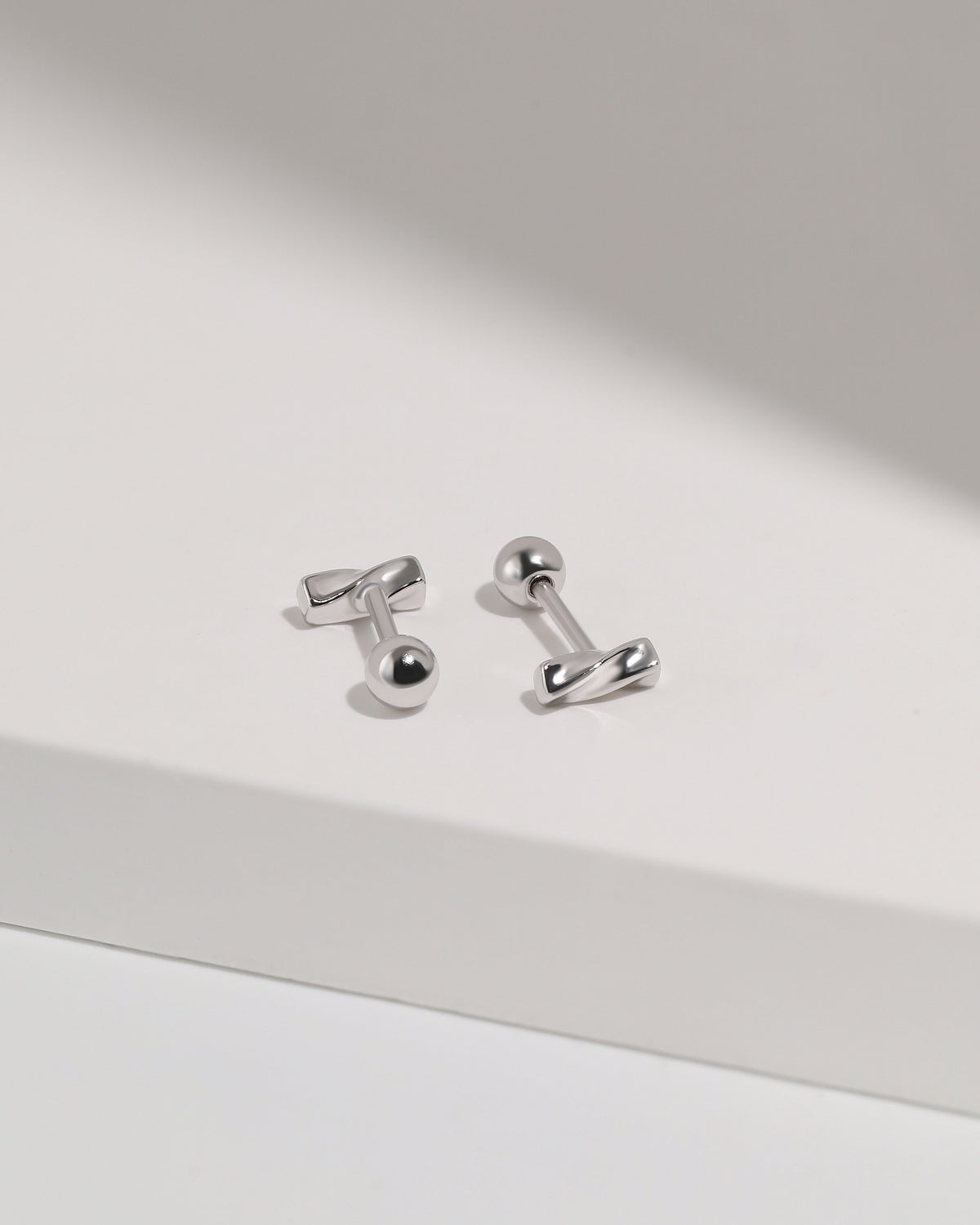 Twist Bar Screw Back Earrings in 925 sterling silver arranged at different angles to show the sculpted twist design and round screw back closures.