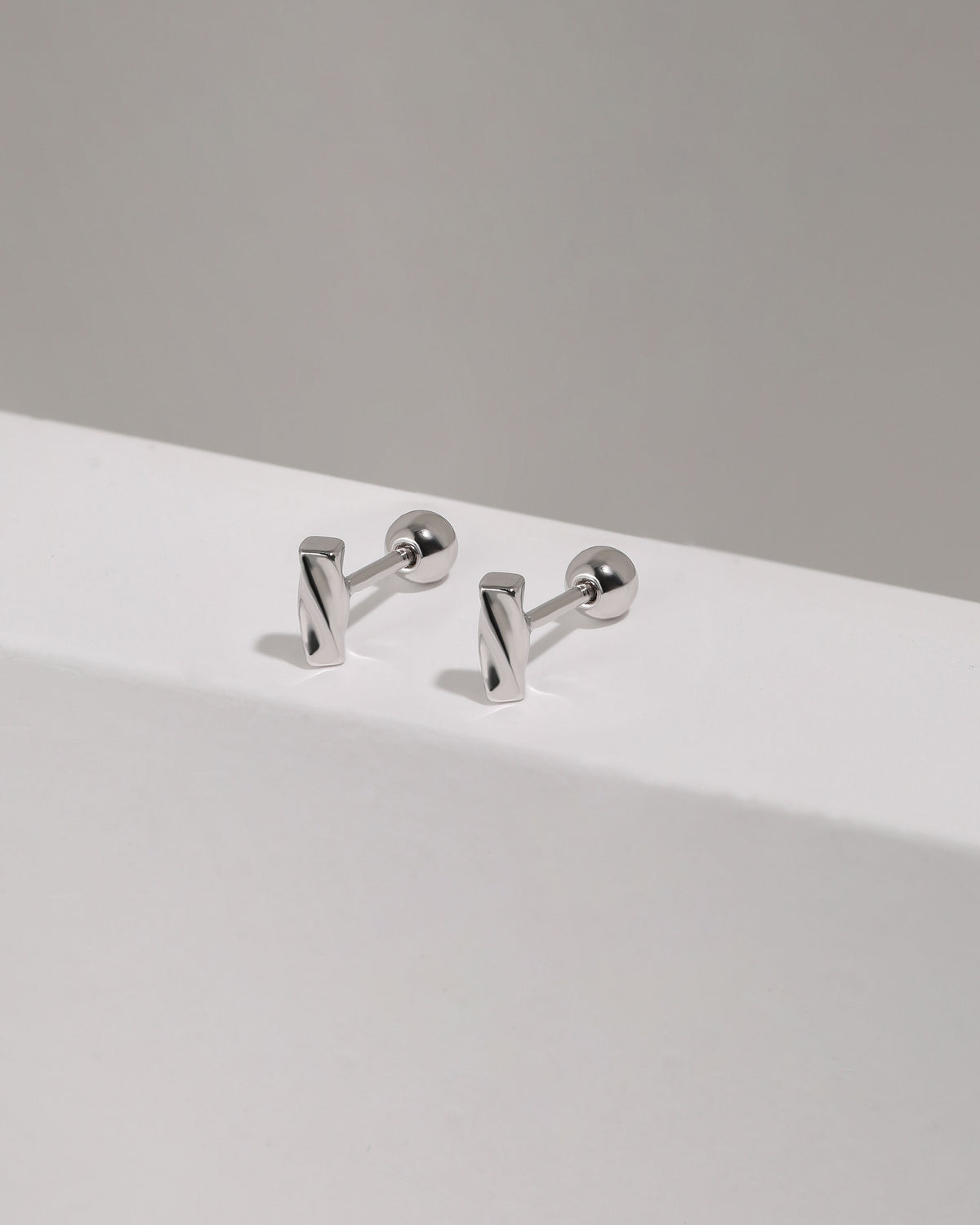 Pair of Twist Bar Screw Back Earrings standing upright, highlighting the polished rectangular twisted bar design and secure screw back style.