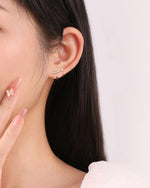 Model wearing silver-tone Meissa Sparkling Bar Huggie Hoop Earrings with clear stones in a stacked ear look.