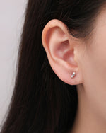 Twist Bar Screw Back Earring worn on the earlobe, highlighting the slim rectangular shape and sculpted twist detail in polished silver.