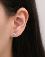 Close-up of a Cross Sparkle Screw Back Earring worn on the earlobe, showing the detailed cubic zirconia cross design and petite size.
