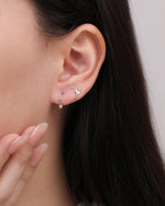 Heart Spiral Screw Back Earring in silver color worn on the earlobe, showing the heart detail positioned at the front and the polished ball end beneath the ear.