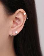 Star Spiral Screw Back Earrings worn on the ear, showing the polished star detail and curved spiral design for multiple piercing placements.