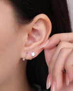 Star Spiral Screw Back Earring worn on the earlobe, highlighting the polished star front, curved spiral shape, and ball back detail.