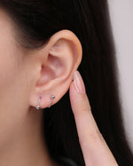 Ball Spiral Screw Back Earring in silver color worn on the ear, showing how the curved spiral design wraps around the earlobe.