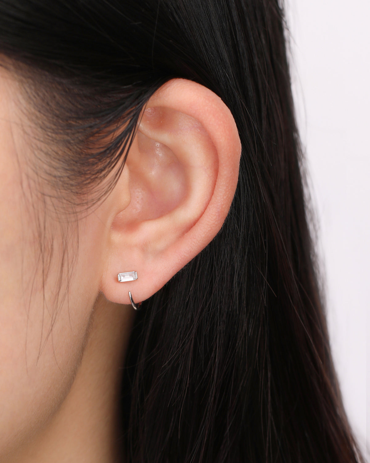 Model wearing silver-tone Meissa Baguette Sparkle Huggie Hoop Earrings in a minimalist ear look.