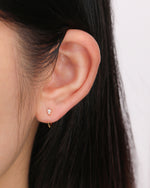 Model wearing gold-tone Meissa Pear Sparkle Huggie Hoop Earrings in a minimalist ear look.