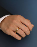 Gold Nova Track Ring in stainless steel worn on a man's hand, featuring a round cubic zirconia center stone and polished track-inspired details.