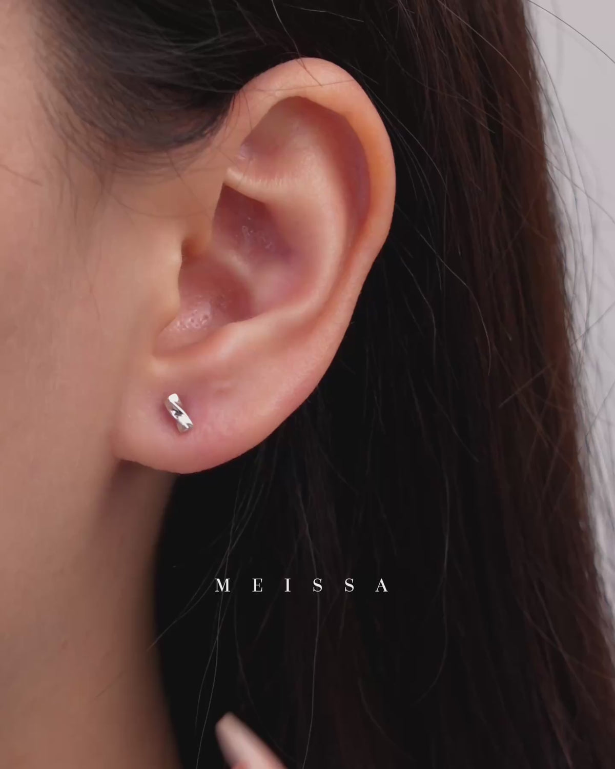 Twist Bar Screw Back Earrings in 925 sterling silver, shown worn on the earlobe and displayed on fingertips to highlight the petite size, polished twist bar design, and minimalist everyday style.